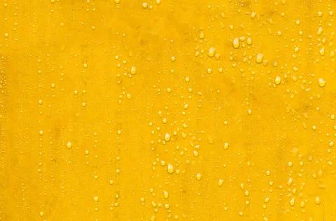 Wassertropfen bilden sich auf einer leuchtend gelben, wasserfesten Oberflä.. Stock Photos