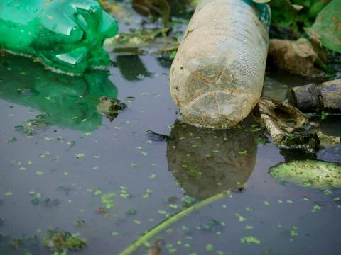 Wastage material plastic pollution presented on gutter water, Dirty polluted  Stock Photos