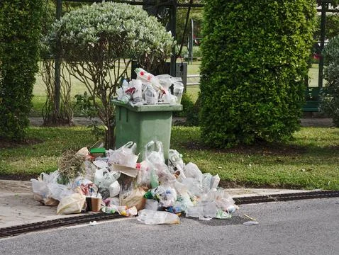 Waste Bin and Overflowing Garbage on Street Stock Photos