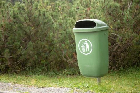 Waste bin in front of conifer trees Stock Photos