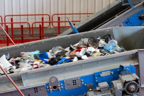 Waste conveyor system transporting mixed plastic materials in recycling plant Stock Photos