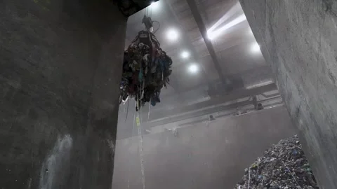 Waste handling claw lifting mixed material inside processing plant Stock Footage 334633507