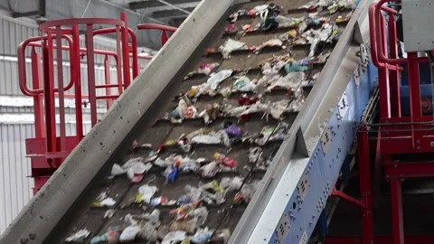 Waste load transported through elevated conveyor section in recycling hall Stock Footage 333345335