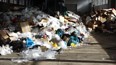 Waste management facility interior showing large pile of recyclable material Video stock 278513046