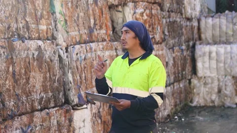 Waste management worker inspecting plastic bale recycling in slow motion Stock Footage 313917969