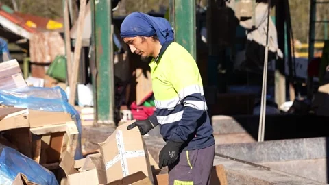 Waste management worker sorting recyclable materials in slow motion Stock Footage 313917953