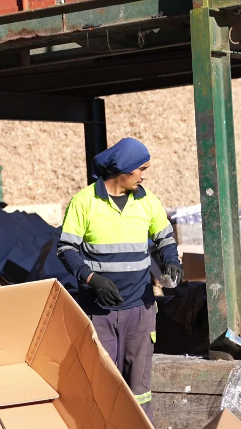 Waste management worker unloading cardboard boxes in slow motion Stock Footage 313924343