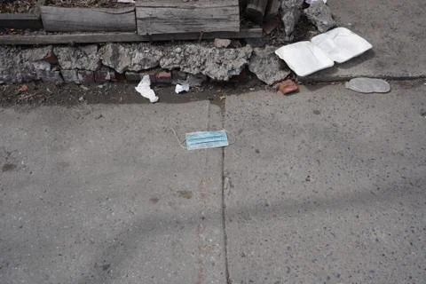 A waste mask on the sidewalk Фото