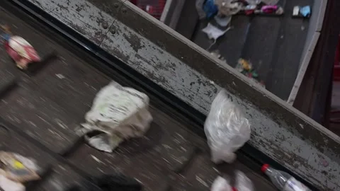 Waste materials carried upward on angled conveyor in recycling facility Stock Footage 333345365