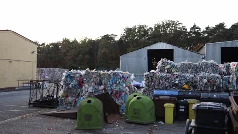 Waste recycling plant with compacted plastic and paper bales stacked near metal  Stock Footage 319833020