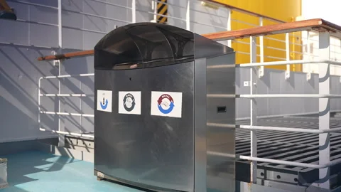 Waste sorting bin on a cruise ship deck against white railings 库存影片 346814135