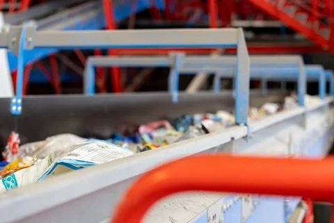Waste sorting conveyor belt inside industrial recycling facility 库存照片