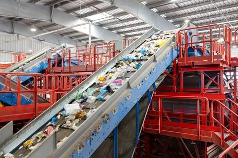 Waste sorting conveyor belt with mixed garbage in recycling plant facility 库存照片