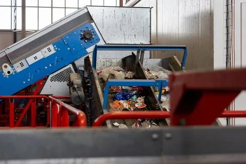Waste sorting conveyor system with inclined belt and mixed plastic in recycling Stock Photos