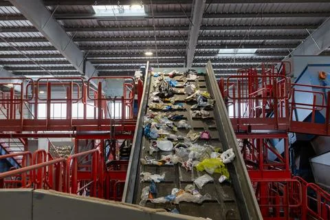 Waste sorting facility conveyor belt with mixed garbage and plastic in recy.. Stock Photos