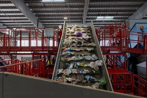 Waste sorting facility conveyor belt with mixed garbage and plastic in recy.. Stock Photos