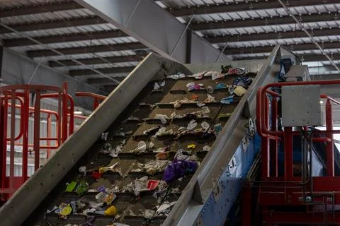 Waste sorting facility conveyor belt with mixed garbage and plastic in recy.. Stock Photos