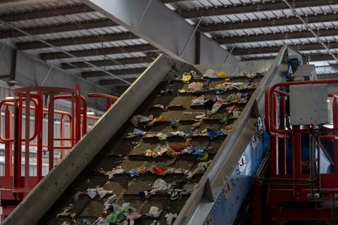 Waste sorting facility conveyor belt with mixed garbage and plastic Stock Photos