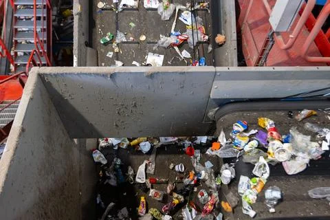 Waste sorting facility conveyor junction with mixed garbage on recycling plan Stock Photos