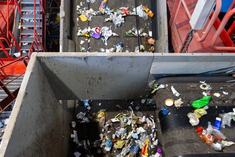 Waste sorting facility conveyor junction with mixed garbage on recycling plan Stock Photos
