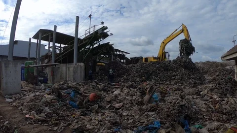 Waste sorting machine working with worker and backhoe in the sanitary landfill Stock Footage 98088027