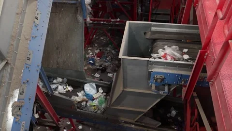 Waste stream carried through mechanical conveyor system in recycling facility Stock Footage 333345385