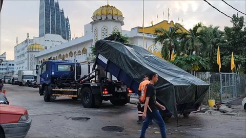 A waste transport vehicle is lifting a bin filled with waste onto the vehicle Stock Footage 339190889