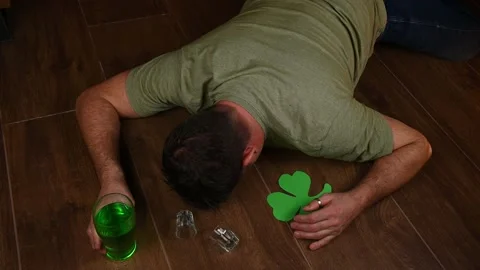 Wasted drunk man passed on on the floor during St Patricks day celebrations Stock Footage 230957032