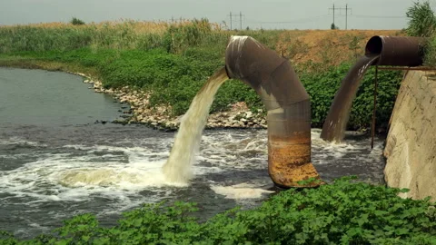 Wastewater from two large rusty pipes merge into the river in clouds of steam Stock Footage 118255342