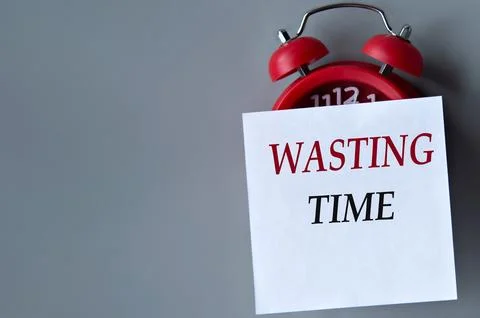 WASTING TIME - words on a white piece of paper on a gray background. Red al.. Stock Photos