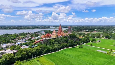 Wat Tham Suea Buddhist temple and green rice fields aerial establishing shot Stock Footage 339091921