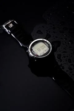 Watch computer for diving in water streams on a black background Stock Photos
