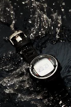 Watch computer for diving in water streams on a black background Stock Photos