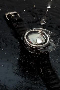 Watch computer for diving in water streams on a black background Stock Photos