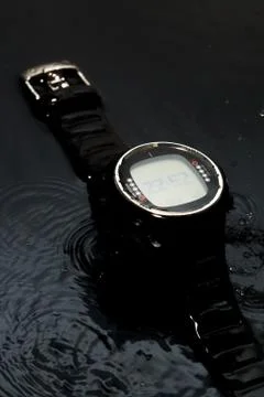 Watch computer for diving in water streams on a black background Stock Photos