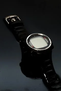Watch computer for diving in water streams on a black background Stock Photos