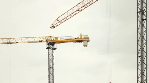 Watch as construction site cranes are actively engaged in lifting and moving Stock Footage 312698409