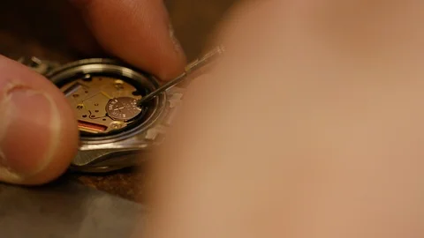 Watch maker removing battery from a wrist watch Stock Footage 101949180