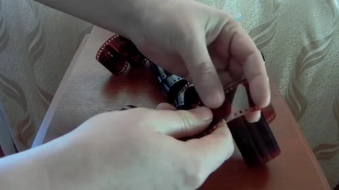 Watch old footage on negative film, twist the film in your hands Stock Footage