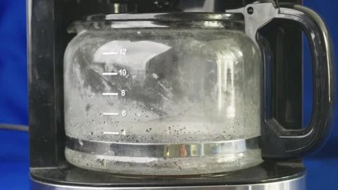Watch the process of dark, hot coffee slowly filling a clear glass carafe within Stock Footage 333059116