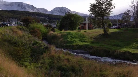 Watch the river flow through the landscape near the mountains Stock Footage 332917874