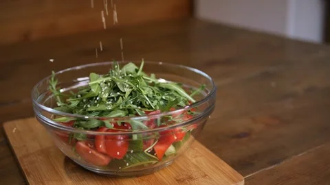 Watch salt cascade onto fresh vegetable salad enhancing every bite. Witness its Stock Footage 264759178