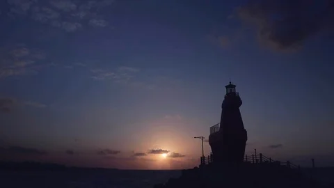 Watch the sunset behind the lighthouse. 4K sunset time lapse. Stock Footage 126329541