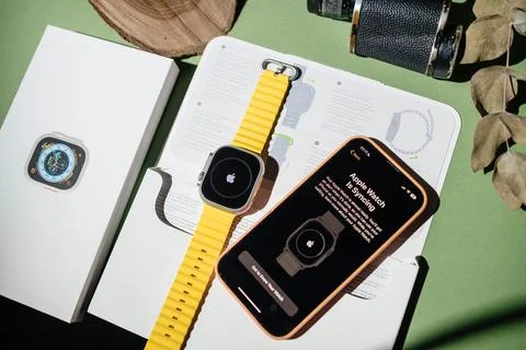 Watch is syncing message on iPhone 14 pro next to new titanium A Stock Photos