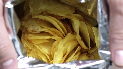 Watch as Unidentified Hands Gracefully Open a Bag of Tempting Potato Chips in Stock Footage 241727978
