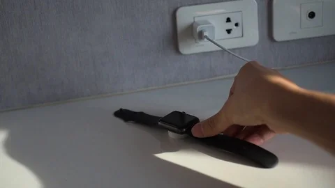 Watch user plugs in Apple Watch to charge the battery. Stock Footage 88772050