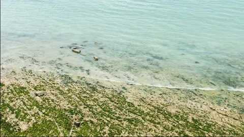 Watching from high as sea waves run onto the sandy shore. The bluish-clear se Stock Footage 133087686