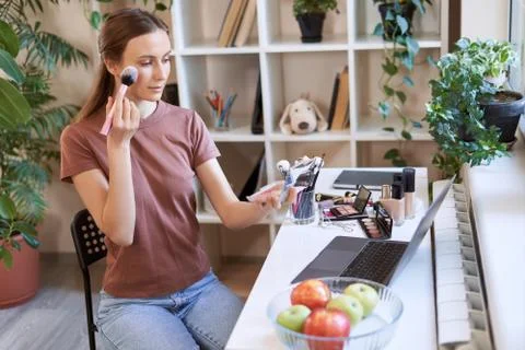 Watching makeup tutorial online. Young beautiful woman in casual clothes 写真素材