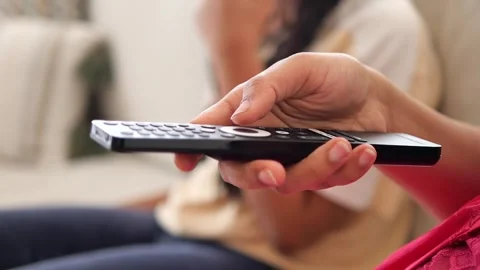 Watching a show while holding a remote control Stock Footage 338219032