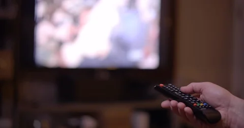 Watching TV and using the Television Remote Control to Change Channels Stock Footage 126972997